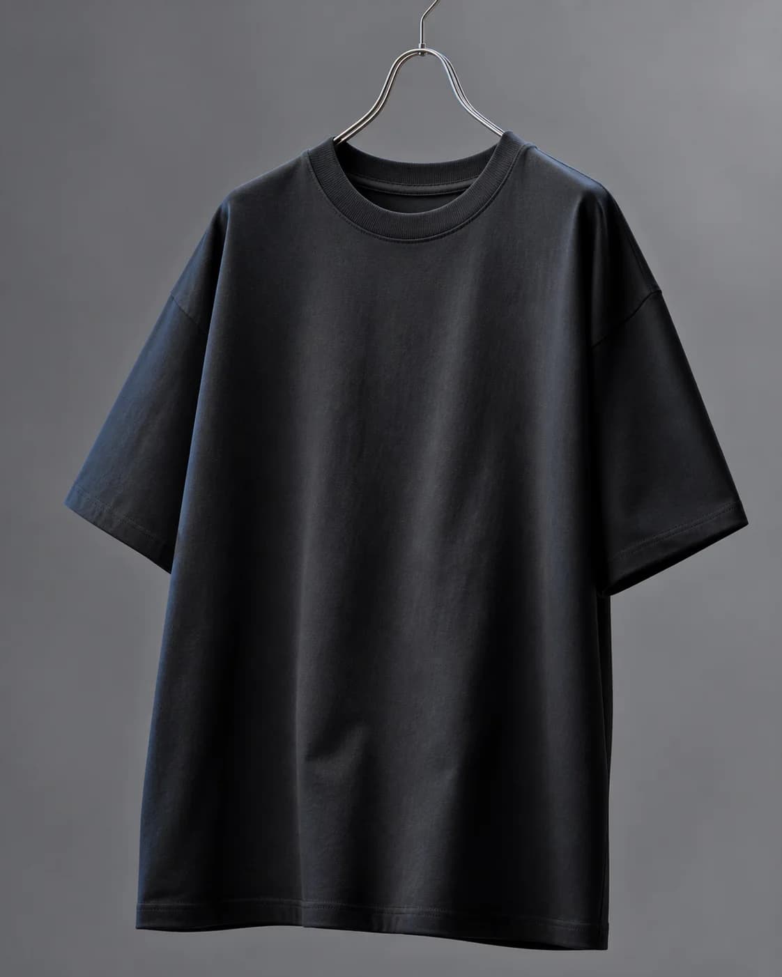 Black heavyweight T-shirt hanging in a studio